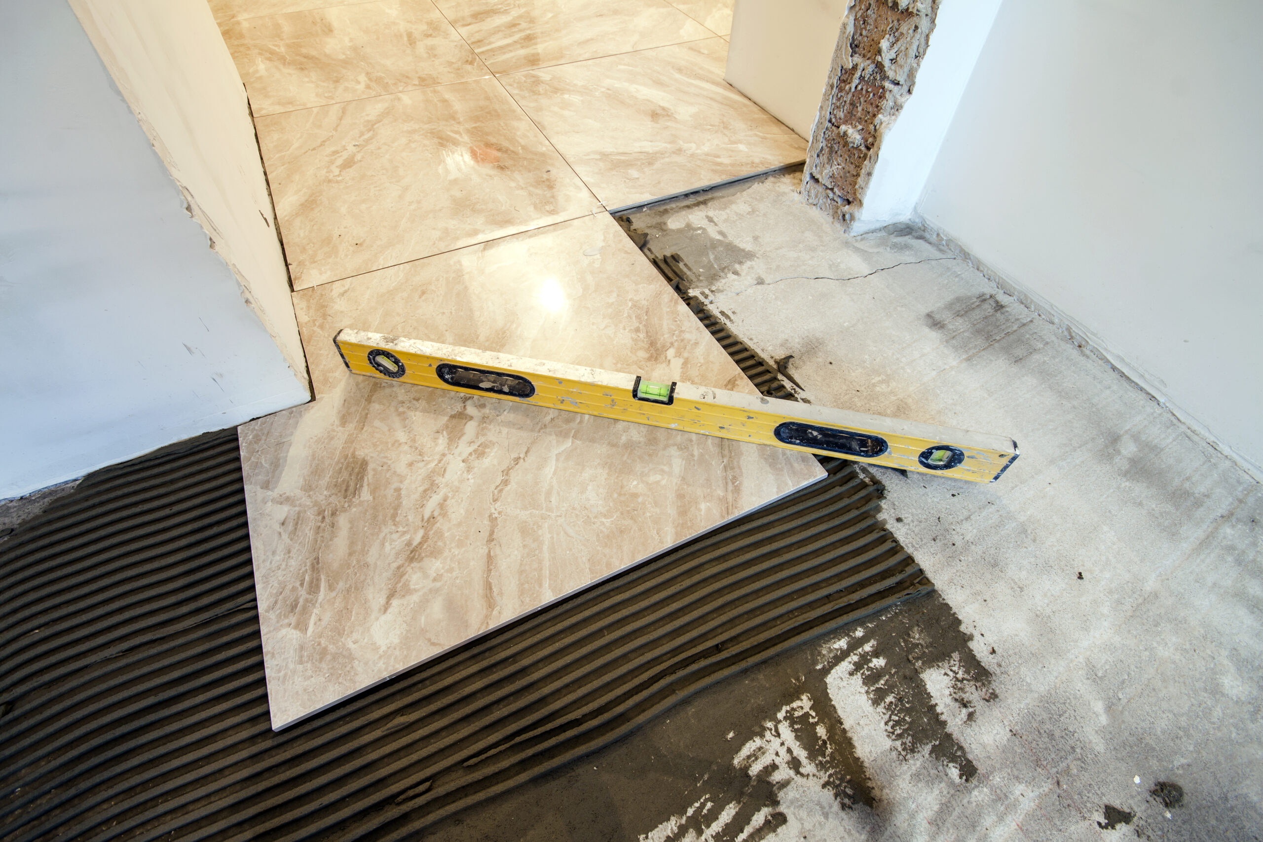 Ceramic tiles and tools for tiler. Floor tiles installation. Home improvement, renovation – ceramic tile floor adhesive, mortar, level Ceramic tiles and tools for tiler. Floor tiles installation. Home improvement, renovation - ceramic tile floor adhesive, mortar, level